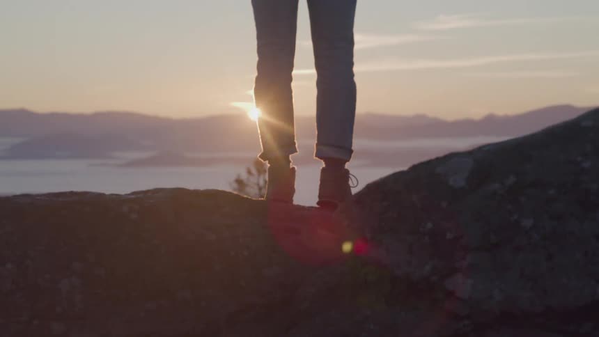 A person stands above the clouds
