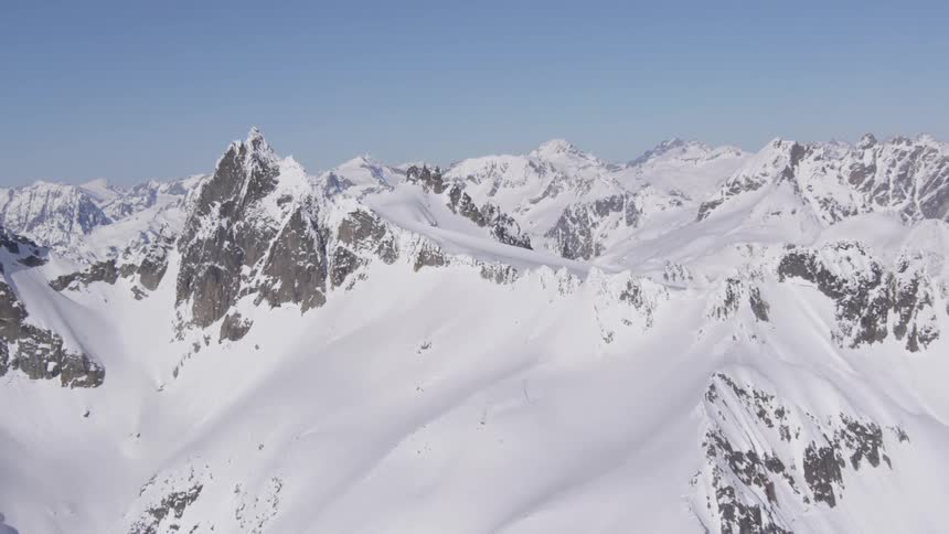 A snowcovered rugged mountain range under a sunny winter sky