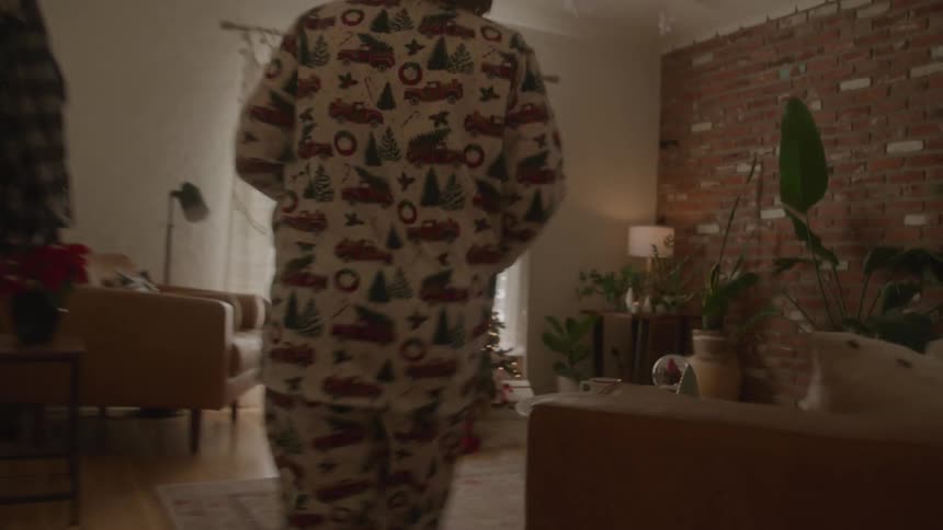 Two children running towards the christmas tree with presents