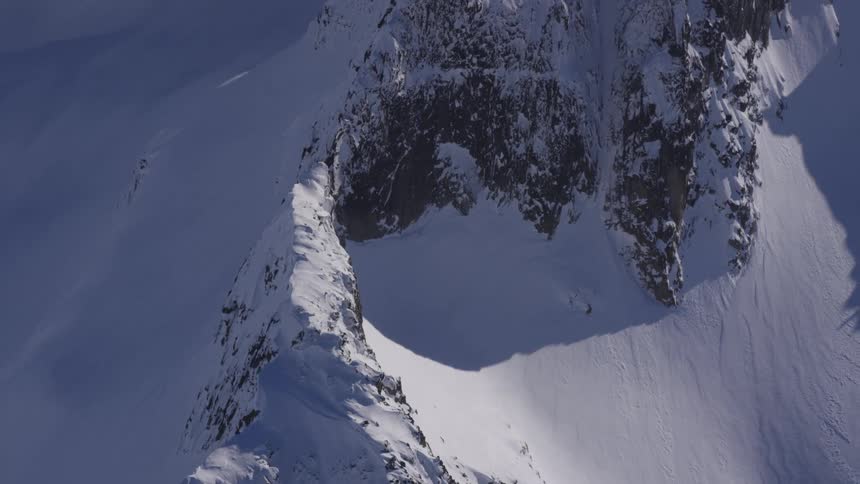 A mountain range in the south pole completely covered in snow at midday