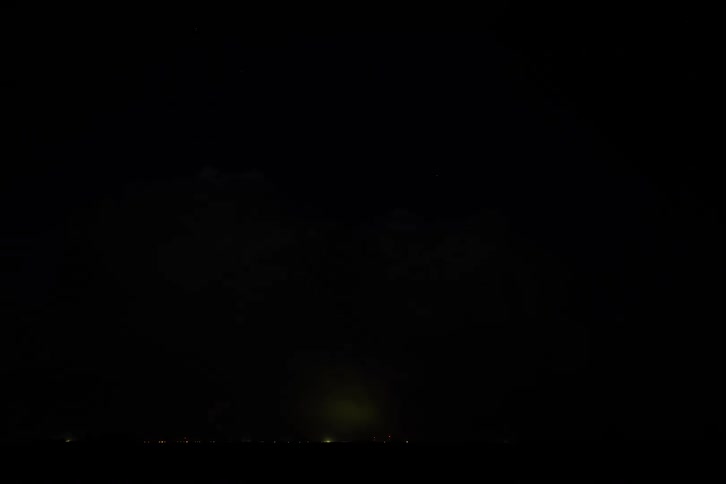 Bright lightning illuminates massive storm clouds at night