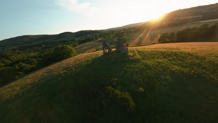 Rolling green hills glow in the warm light of late afternoon under a clear sky