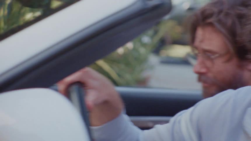 Two men sitting inside a car having a conversation