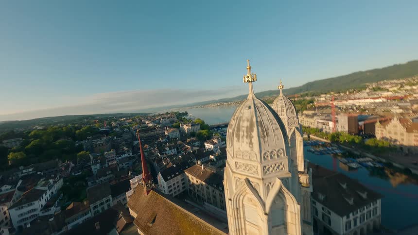 An aerial view of a european city is shown from a high vantage point the video shows a large church with two towers and a river or lake flowing through the city