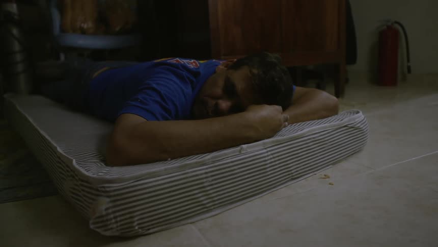 A man is laying on a mattress