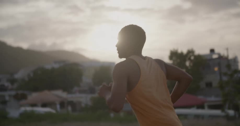 A man is running in a suburban area at dawn