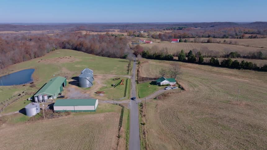 A drone captures farmland with barns and fields