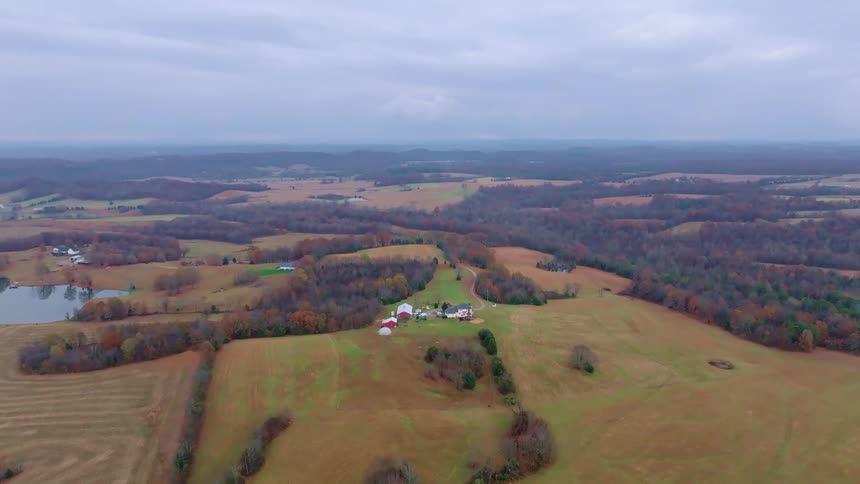 Vast rural fields with a small farm in the center