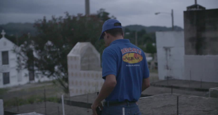A man walks in a cemetery on a cloudy day