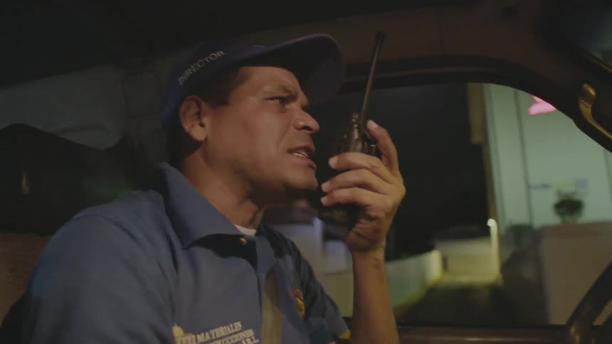 An ambulance driver uses a walkie-talkie as he drives