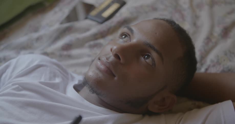 A man is lying in bed and using a walkie-talkie