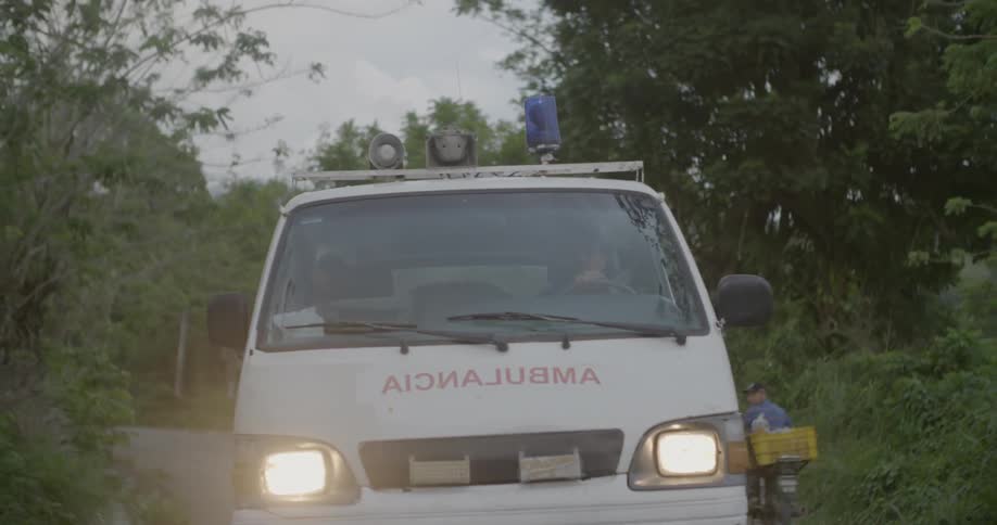 An ambulance is driving with its emergency light on