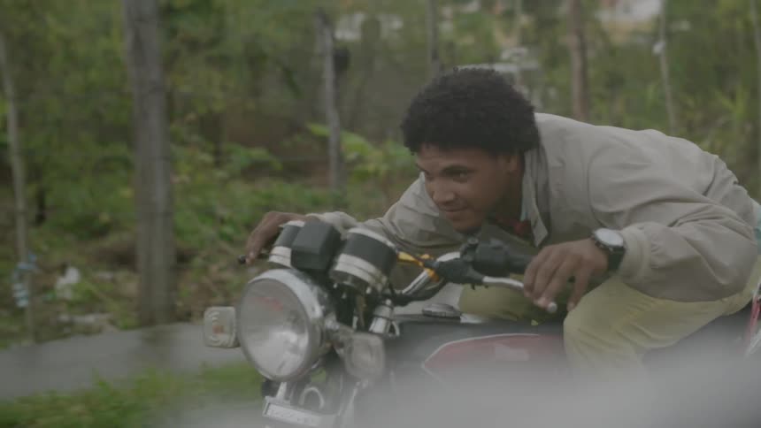A man rides hunched over a motorcycle