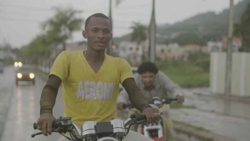 Men ride motorcycles while it rains