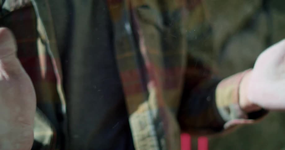 Hands covered in white chalk being rubbed together by a person wearing a plaid shirt
