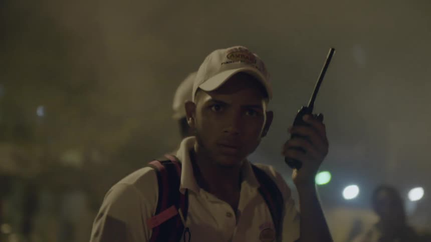 A man is talking on a walkie-talkie and directing others