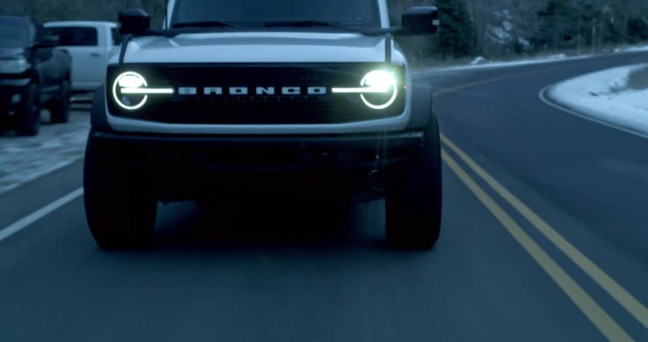 Ford bronco driving on mountain road in the winter