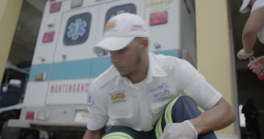 A medical technician is cleaning the ground under him