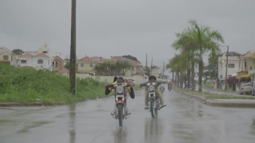 Motorcyclists ride during a rainstorm