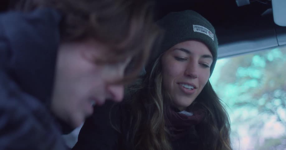 Two young people inside a car talking during cold weather