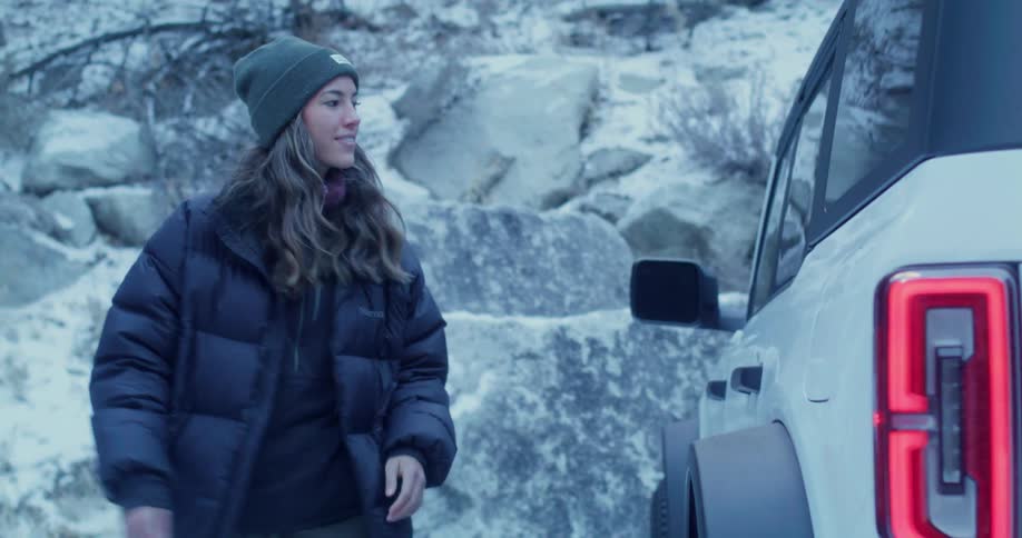 Woman in padded coat opening trunk
