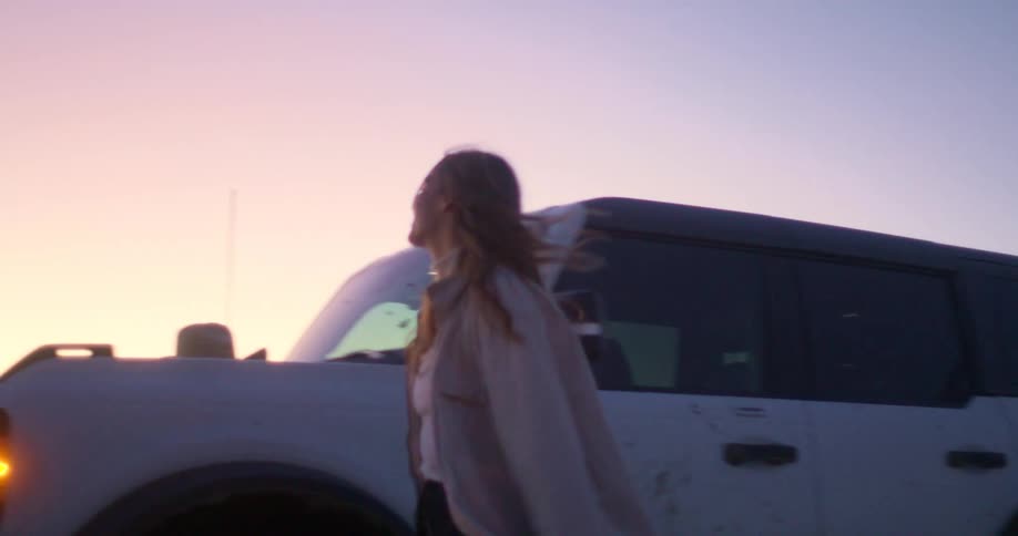 Couple getting out of the car in the middle of a desert and hugging