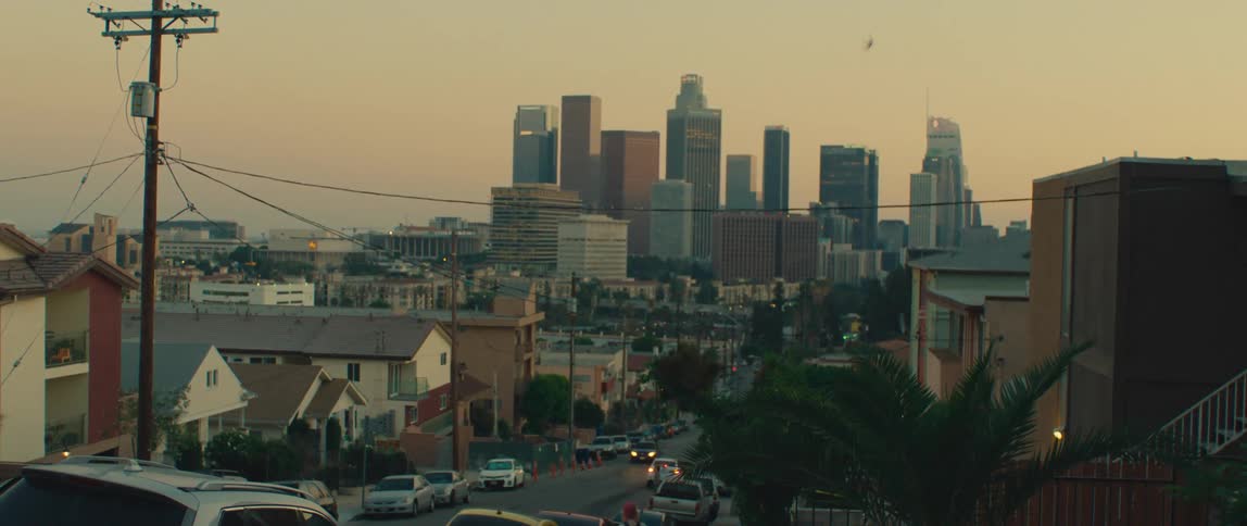 An urban skyline with houses in front at dusk