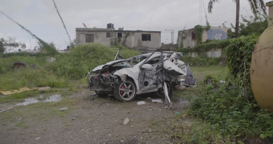 A crashed car sits abandoned outside