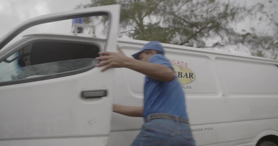 A man runs and jumps into the driver seat of an ambulance