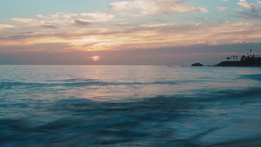 Ocean waves rolling toward the shore at sunset