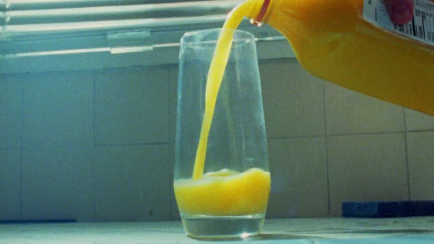 Orange juice being poured into a clear glass