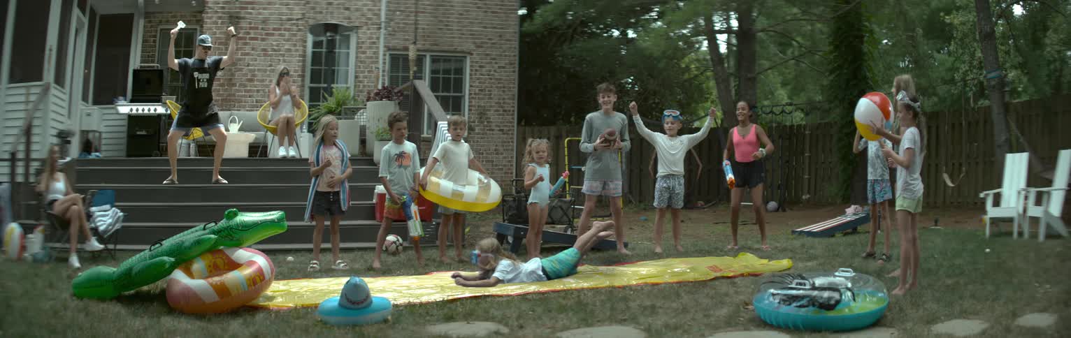 Children and adults enjoy a backyard summer water party