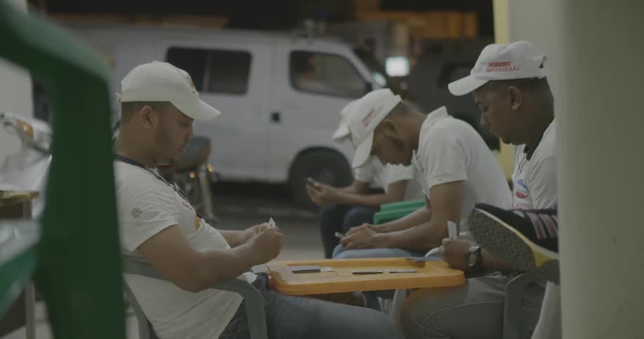 Men play a card game on a makeshift table