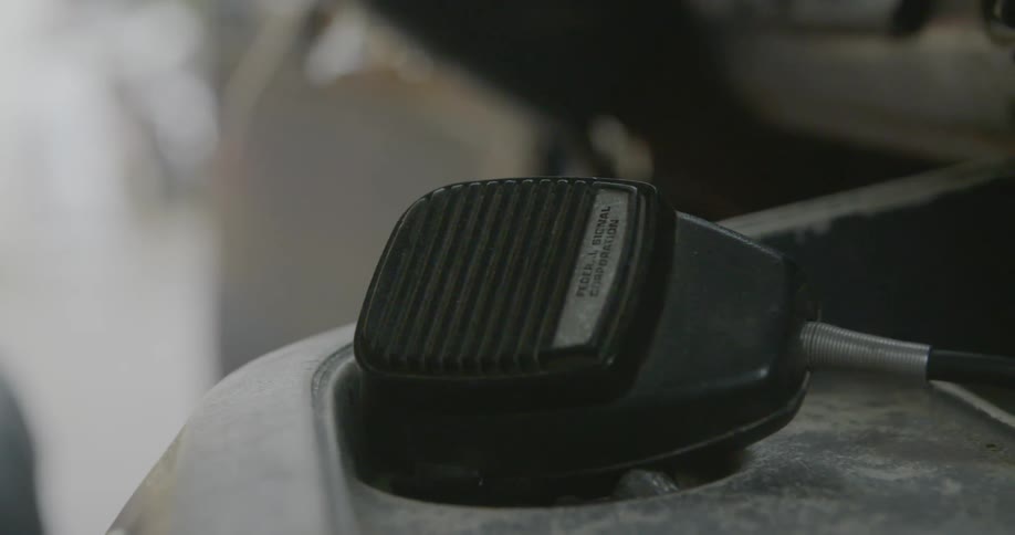 A cb handle laying on the dash or console of a vehicle