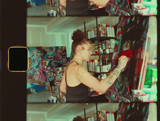 Woman painting a colorful canvas in an art studio