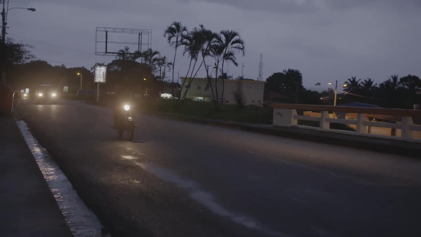 A motorcyclists speeds down a road
