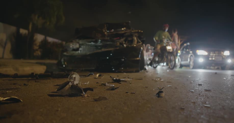 People and vehicles maneuver around a wreckage