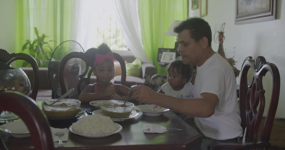A man spoons soup into bowls