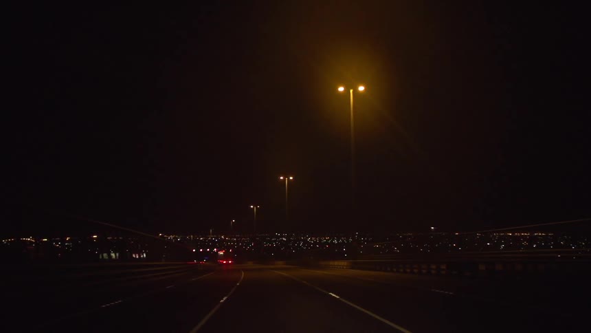 View of a street with tall lamp posts at night