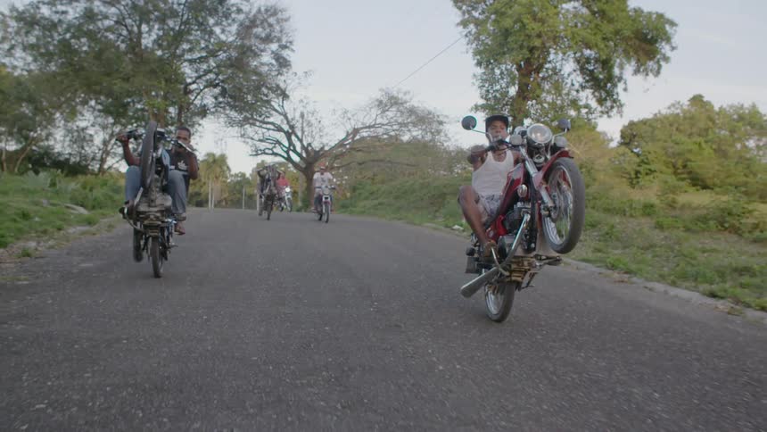 Bikers doing wheelies down the road