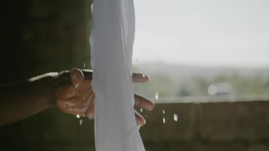 A man lifts a piece of clothing out of a washer