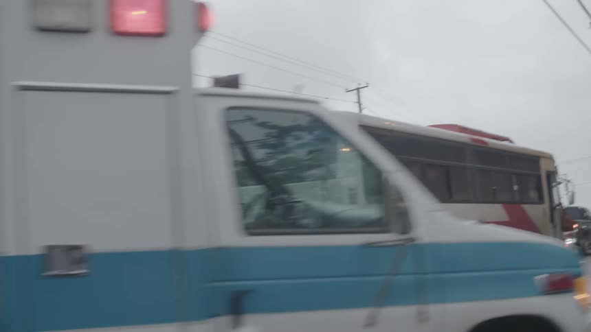 An ambulance rides down the road with lights flashing