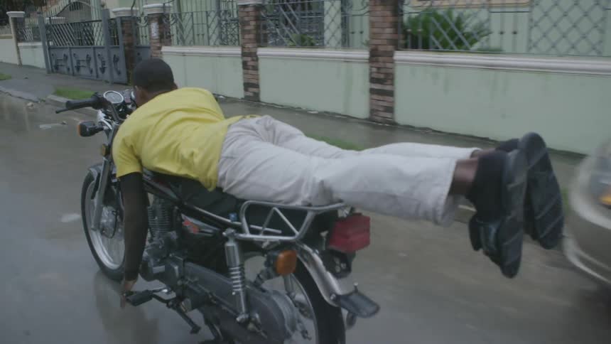 A man lays flat on a running motorcycle