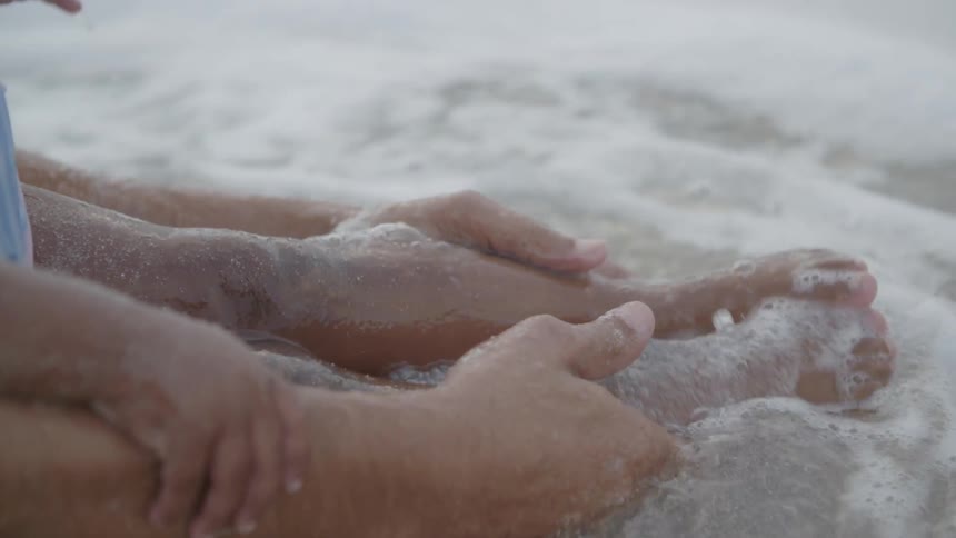 Two people dip into wavy water