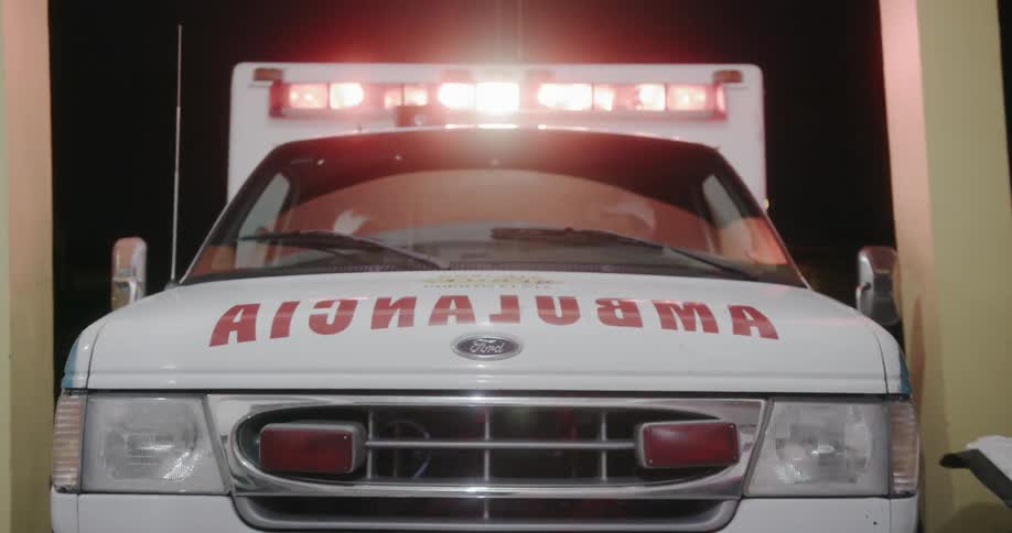 Ambulance backing into a spot with its lights flashing