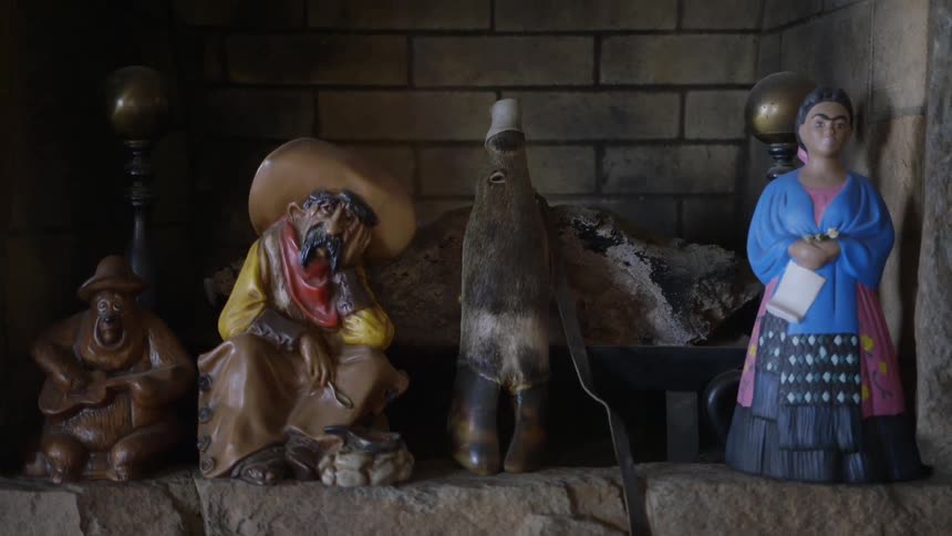 Statues are arranged in front of a fireplace
