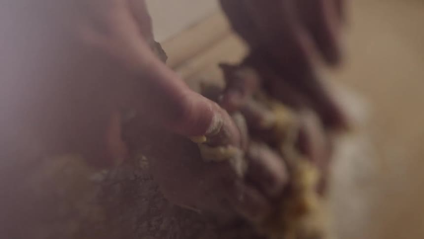 A man is showing a boy how to work with dough