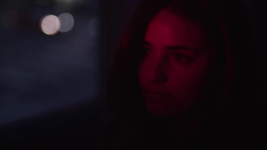 A woman is looking out the window at the driving cars