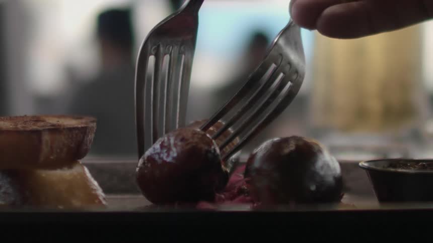 A person cuts a piece of sausage