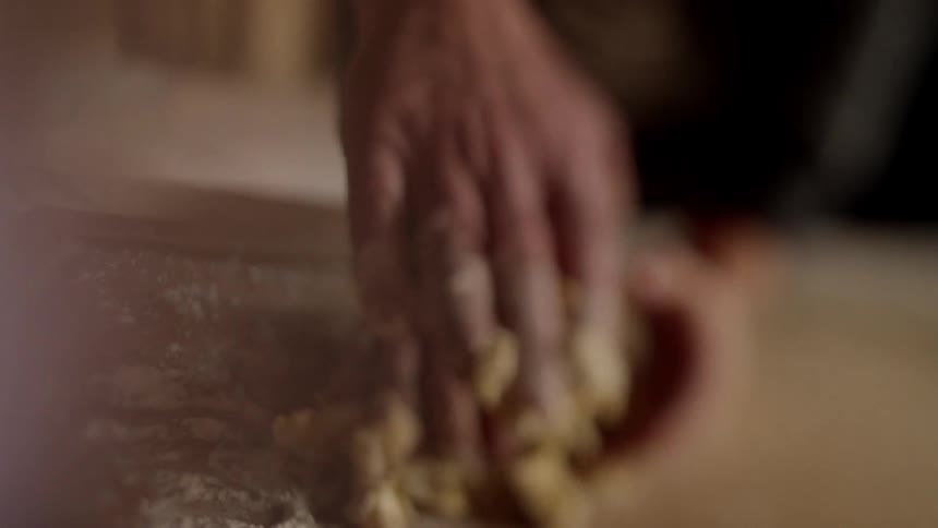 A man is showing a boy how to work with dough